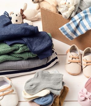 Baby and child clothes, toys in box. Second hand apparel idea