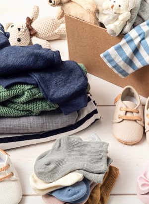 Baby and child clothes, toys in box. Second hand apparel idea