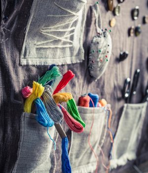 Handmade sewing mat with scissors, threads and needles in tailor workshop